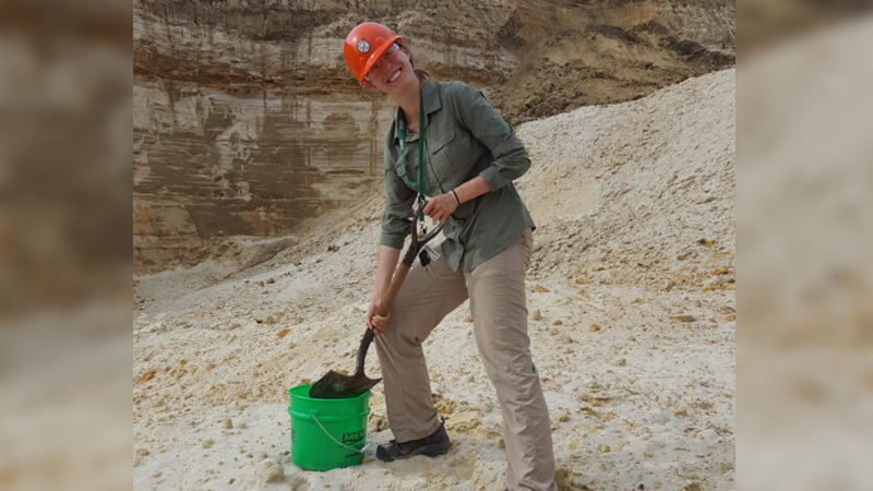 Person shoveling pyrite into bucket.