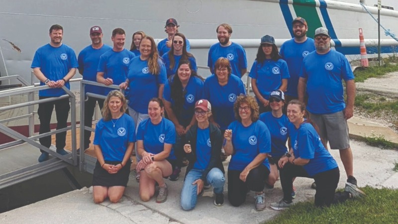 A group of teachers in front of the Lake Guardian boat.